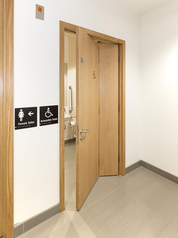 Veneered oak bi-folding accessible wc door supplied by Shadbolt to the Institute of Physics building